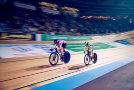 Bahnradfahrer im Rennen auf einer steilen Holzradbahn bei einem internationalen Bahnrad-Event in Berlin. 