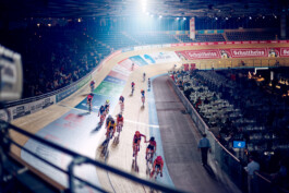 Bahnradfahrer im Rennen auf einer steilen Holzradbahn bei einem internationalen Bahnrad-Event in Berlin. 