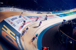 Bahnradfahrer im Rennen auf einer steilen Holzradbahn bei einem internationalen Bahnrad-Event in Berlin. 