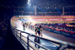 Bahnradfahrer im Rennen auf einer steilen Holzradbahn bei einem internationalen Bahnrad-Event in Berlin. 