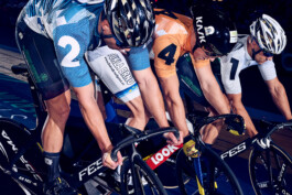 Bahnradfahrer im Rennen auf einer steilen Holzradbahn bei einem internationalen Bahnrad-Event in Berlin. 