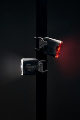 Schwarzer Fahrradhelm mit Belüftungsöffnungen, freigestellt vor dunklem Hintergrund. 