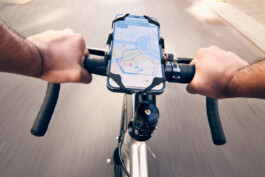 Radfahrer befestigt sein Smartphone an einer modernen Lenker-Halterung – smartes Zubehör für urbane Mobilität und Fahrrad-Navigation. 