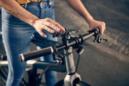 Radfahrer befestigt sein Smartphone an einer modernen Lenker-Halterung – smartes Zubehör für urbane Mobilität und Fahrrad-Navigation. 