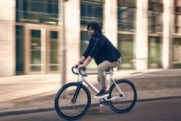 Radfahrer befestigt sein Smartphone an einer modernen Lenker-Halterung – smartes Zubehör für urbane Mobilität und Fahrrad-Navigation. 