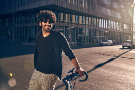 Radfahrer befestigt sein Smartphone an einer modernen Lenker-Halterung – smartes Zubehör für urbane Mobilität und Fahrrad-Navigation. 