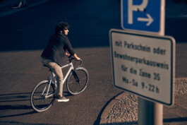 Radfahrer befestigt sein Smartphone an einer modernen Lenker-Halterung – smartes Zubehör für urbane Mobilität und Fahrrad-Navigation. 