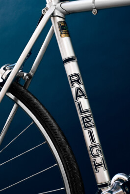 Nahaufnahme eines silbernen Vintage Raleigh Rennrad-Rahmens mit Reynolds 531 Rohrsatz-Sticker und klassischem schwarzem Logo-Schriftzug. 