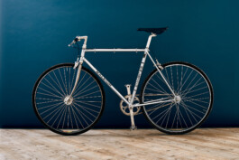 Nahaufnahme eines silbernen Vintage Raleigh Rennrad-Rahmens mit Reynolds 531 Rohrsatz-Sticker und klassischem schwarzem Logo-Schriftzug. 