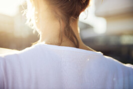Junge Frau fährt mit einem minimalistischen City-Bike durch eine moderne Berliner Straße. 